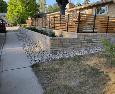 Stone retaining wall with a horizontal wood fence