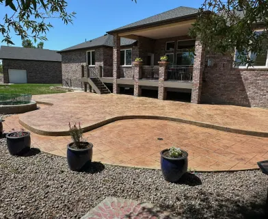 Curved stamped concrete patio with potted plants