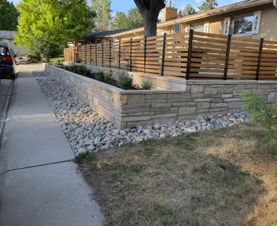 Stone retaining wall with a horizontal wood fence