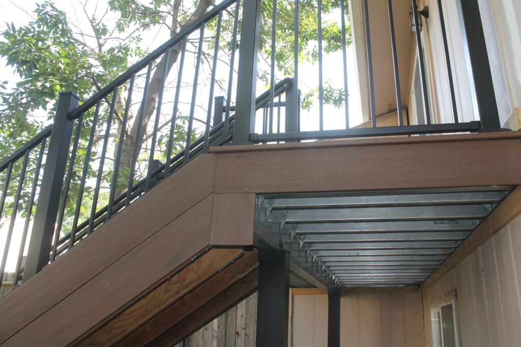 Steel deck frame under a composite deck with stairs and black railing